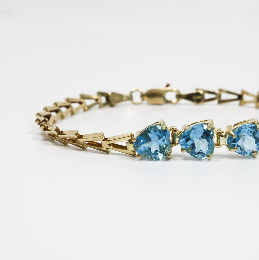 YELLOW GOLD LADY'S BRACELET WITH BLUE HEART CUT STONES.