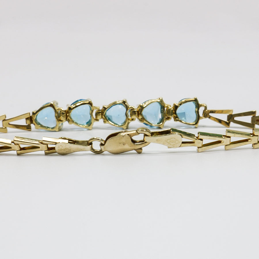 YELLOW GOLD LADY'S BRACELET WITH BLUE HEART CUT STONES.