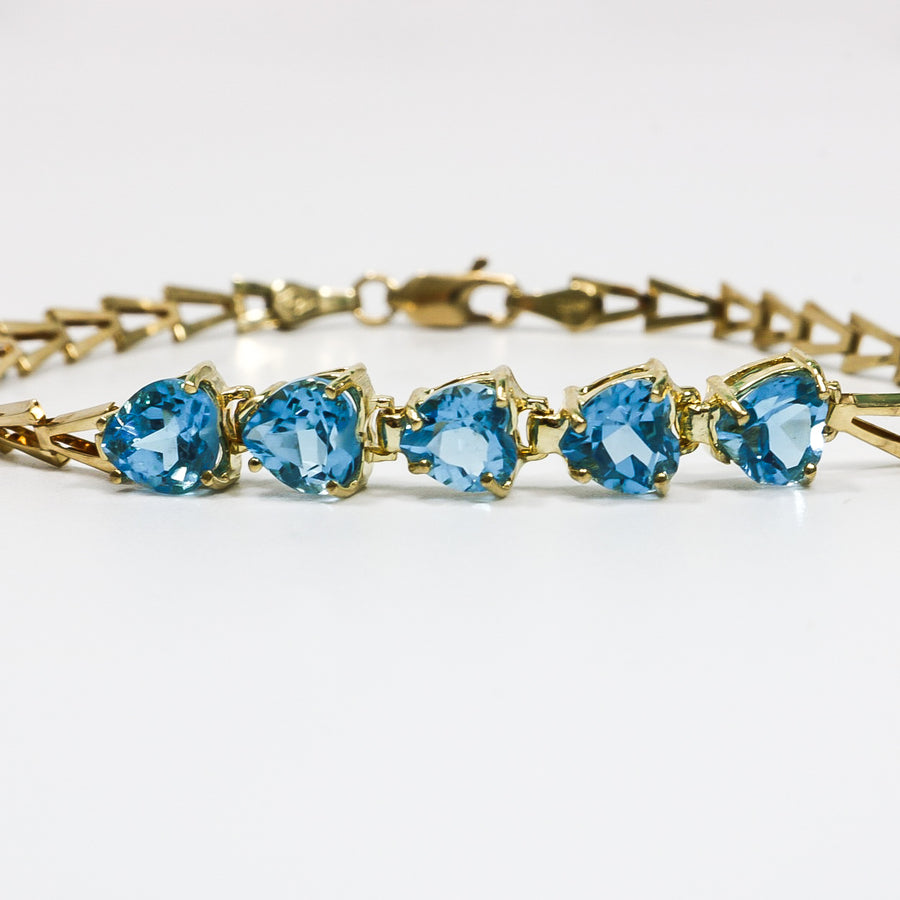 YELLOW GOLD LADY'S BRACELET WITH BLUE HEART CUT STONES.